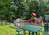 Thumbnail 17 of 18 - Outdoor picnic area with grills and playground at Park at Winterset Apartments, Owings Mills