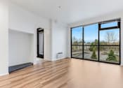 Thumbnail 10 of 26 - A room with a sliding glass door and a wooden floor.