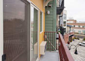 Thumbnail 3 of 26 - A balcony with a metal railing and a glass door.