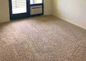 Thumbnail 22 of 26 - A room with a carpeted floor and a sliding glass door.