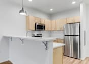 Thumbnail 15 of 26 - A kitchen with a white counter and a stainless steel refrigerator.
