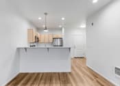 Thumbnail 12 of 26 - A kitchen with white cabinets and a white island.