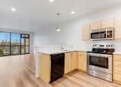 Thumbnail 13 of 26 - A kitchen with a stove top oven and microwave above it.