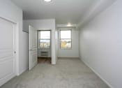 Thumbnail 25 of 26 - A white room with a door and a window.