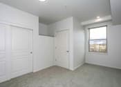 Thumbnail 24 of 26 - A white room with a door, a window, and a ceiling light.
