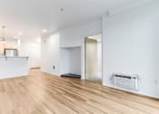 Thumbnail 9 of 26 - A room with a white wall and a wooden floor.