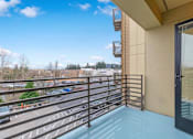 Thumbnail 4 of 26 - A balcony with a metal railing and a glass door.