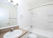 Thumbnail 34 of 47 - A white bathroom with a sink, toilet, and bathtub.