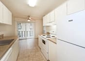 Thumbnail 31 of 47 - A kitchen with white appliances and cabinets.