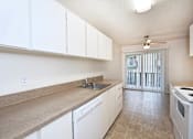 Thumbnail 30 of 47 - A kitchen with white cabinets and a counter top.