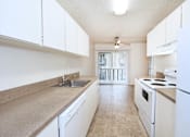 Thumbnail 29 of 47 - A kitchen with white appliances and cabinets.