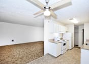 Thumbnail 28 of 47 - A kitchen with white appliances and a ceiling fan.