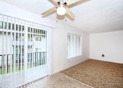 Thumbnail 27 of 47 - A room with a ceiling fan and a carpeted floor.