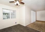 Thumbnail 22 of 47 - A room with a ceiling fan and a window with blinds.