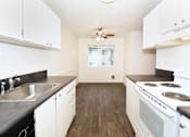 Thumbnail 17 of 47 - A kitchen with white cabinets and a stove top oven.