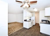 Thumbnail 16 of 47 - A kitchen with white cabinets and a wood floor.