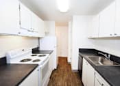 Thumbnail 18 of 47 - A kitchen with white cabinets and a black countertop.