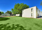 Thumbnail 11 of 48 - a large yard in front of a white building and a tennis court