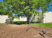 Thumbnail 26 of 48 - a swing set in a park in front of a building