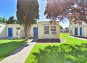 Thumbnail 15 of 48 - a white building with blue doors and a lawn and trees
