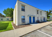 Thumbnail 19 of 48 - a white building with a blue door and a sidewalk