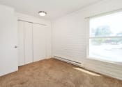 Thumbnail 46 of 48 - a bedroom with a window and white walls and carpet