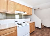 Thumbnail 37 of 48 - an empty kitchen with white appliances and wooden cabinets