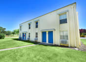 Thumbnail 9 of 48 - an old white building with blue doors and a lawn