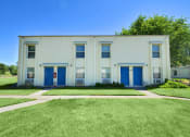 Thumbnail 16 of 48 - the front of a white building with blue doors