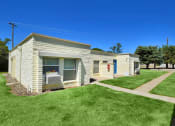 Thumbnail 13 of 48 - a small white building with a lawn and a sidewalk