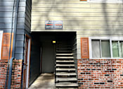 Thumbnail 11 of 47 - A house with a grey siding and a brown door.