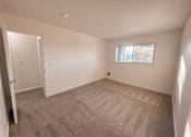 Thumbnail 43 of 47 - A room with a carpeted floor and a window.