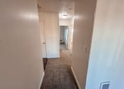 Thumbnail 42 of 47 - A long hallway with a door on the left and a window on the right.
