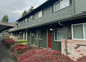 Thumbnail 7 of 25 - A green building with red doors and windows.