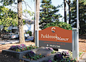 Thumbnail 4 of 47 - a sign for parkbrook manor in front of trees and flowers