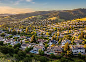 Thumbnail 3 of 7 - A sunset view of a residential neighborhood nestled in the hills.
