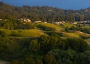 Thumbnail 4 of 7 - A small town nestled in a valley with a river running through it.