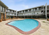 Thumbnail 5 of 25 - A swimming pool in a courtyard surrounded by buildings.