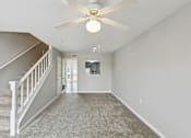 Thumbnail 20 of 25 - A spacious room with a carpeted floor and a ceiling fan.