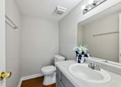 Thumbnail 25 of 25 - A white toilet sits next to a sink in a small bathroom.