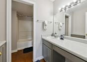 Thumbnail 14 of 25 - A bathroom with a white sink and a white door.