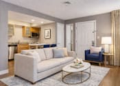 Thumbnail 3 of 18 - A living room with a white couch and a coffee table.