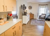 Thumbnail 16 of 24 - a kitchen with wooden cabinets and a living room with a couch and a table