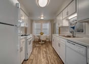Thumbnail 2 of 32 - A kitchen with white appliances and wooden floors.