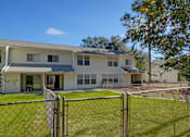 Thumbnail 16 of 32 - A house with a fence in front of it.