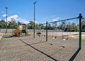 Thumbnail 26 of 32 - A playground with a swing set and a slide.
