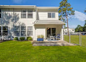 Thumbnail 14 of 32 - A house with a white exterior and a covered patio area.