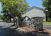 Thumbnail 21 of 29 - A stone sign that says Sleepyfield Square stands in front of a house at Sedgefield Square Apartments, Greensboro, NC