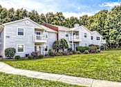 Thumbnail 22 of 29 - A row of houses with green lawns in front at Sedgefield Square Apartments, Greensboro, NC, 27407
