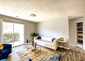 Thumbnail 4 of 29 - A living room with a white couch and a blue chair at Sedgefield Square Apartments, Greensboro, 27407